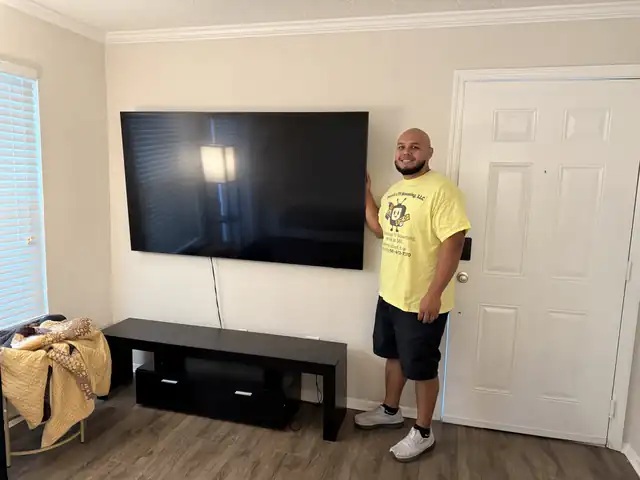 TV mounted on a wall above a black media stand in a Jupiter, FL home